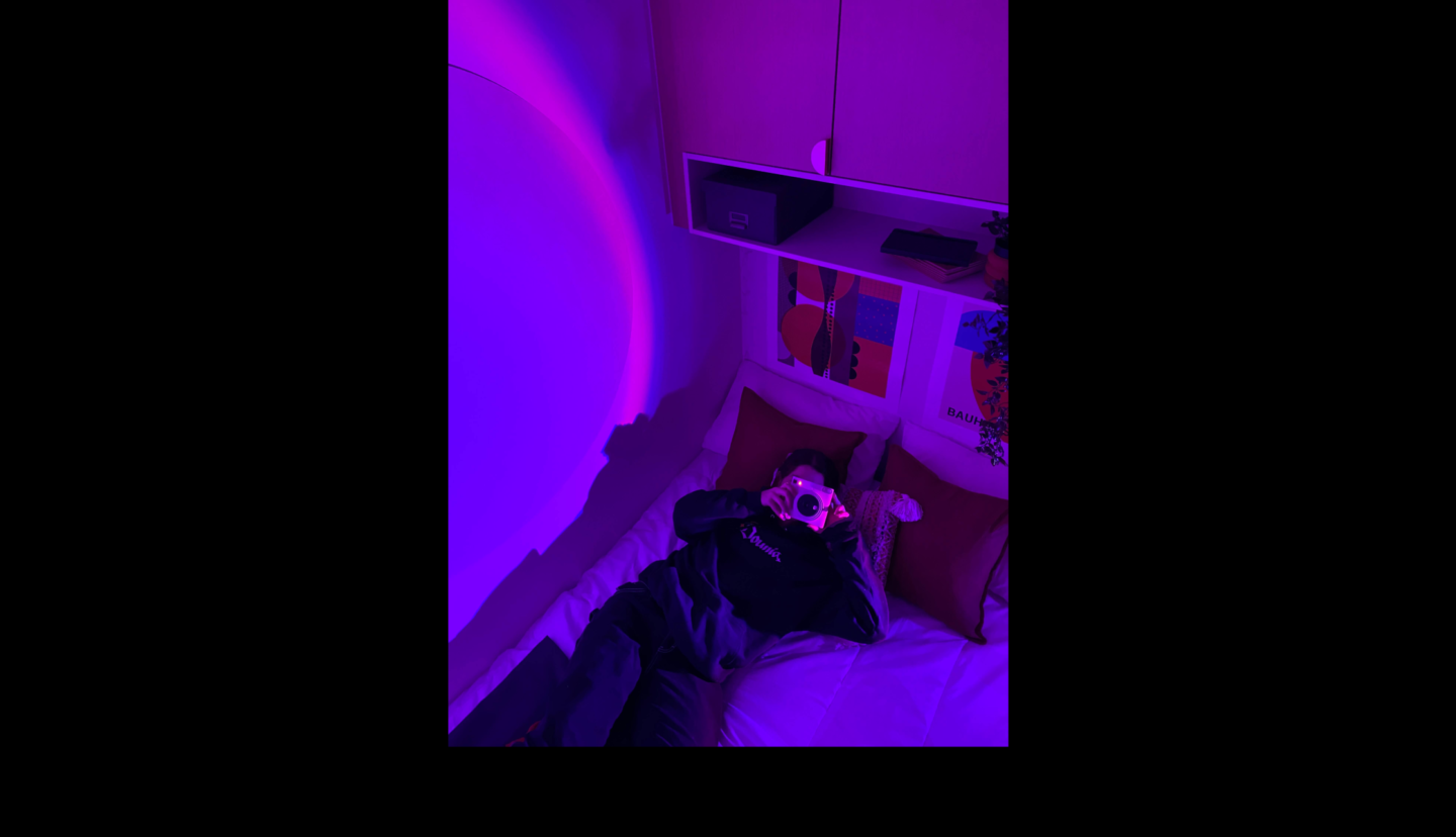 étudiant prenant un polaroid sur le lit